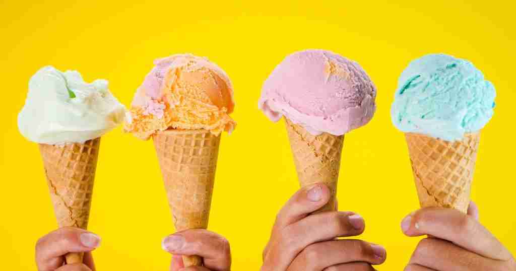 a person holding ice cream cones